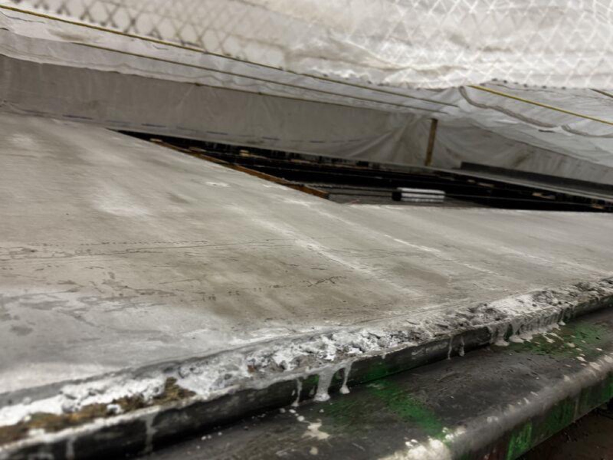 Insulated curing blankets covering a fresh concrete bed during a cold-weather overnight cure