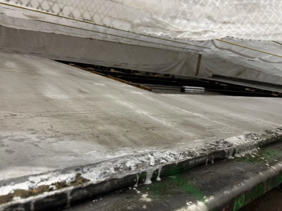 Cobijas térmicas de curado cubriendo una cama de concreto fresco durante un curado nocturno en clima frío