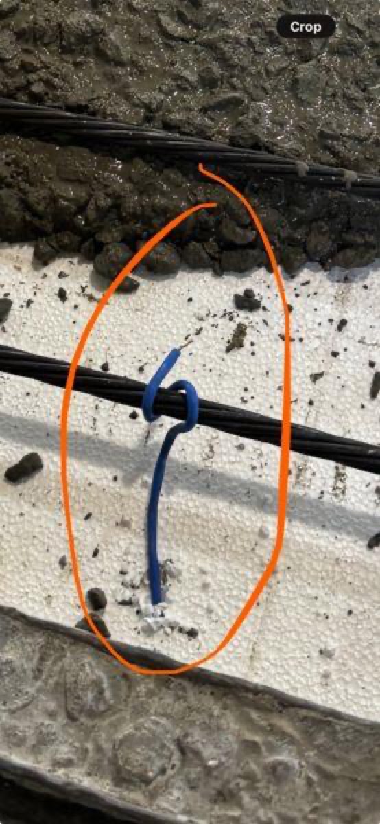 Legacy system Type K thermocouple wire wrapped around a prestressing strand at the insulation boundary — a placement that can bias the temperature reading toward the steel