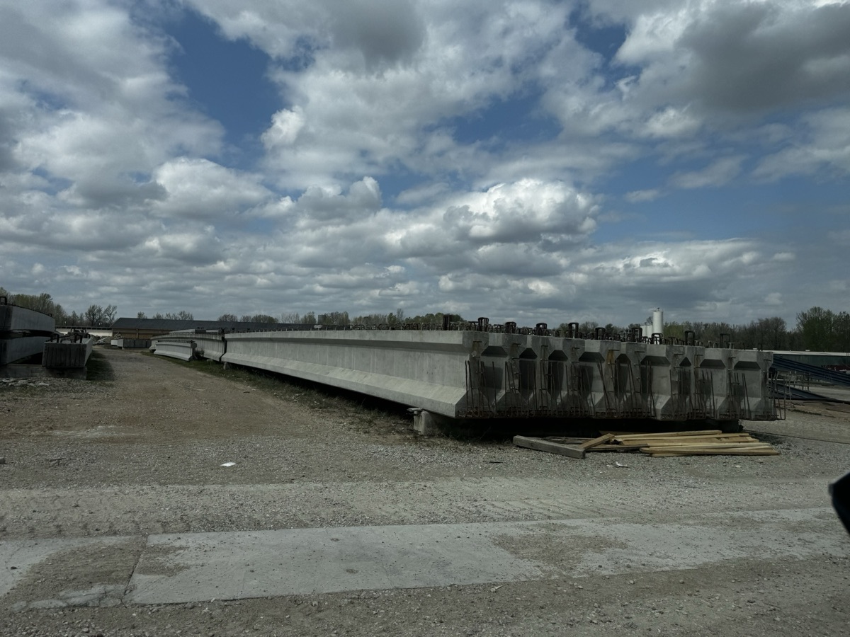 Row of prestressed concrete bridge girders at a precast manufacturing yard