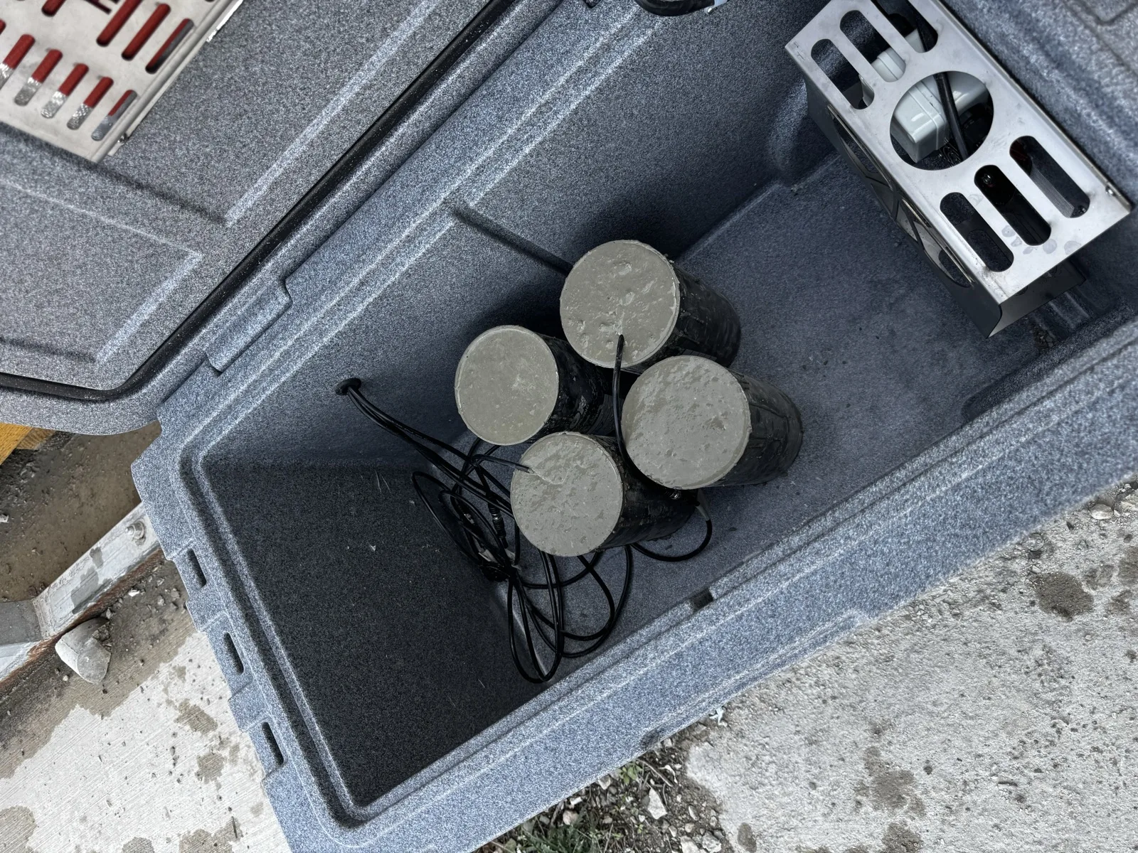 Cilindros de prueba de concreto dentro de una caja de curado igualado SensyCure con ambiente de temperatura controlada que iguala las condiciones del panel in situ